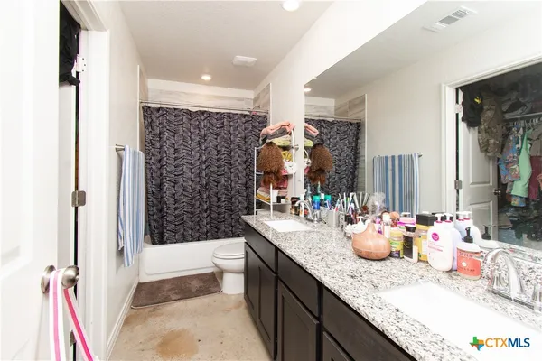 a bathroom with a granite countertop sink and a large mirror