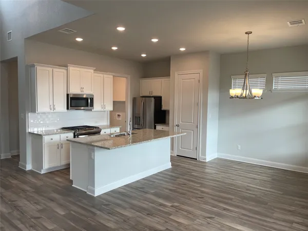 a kitchen with stainless steel appliances granite countertop a stove and a refrigerator