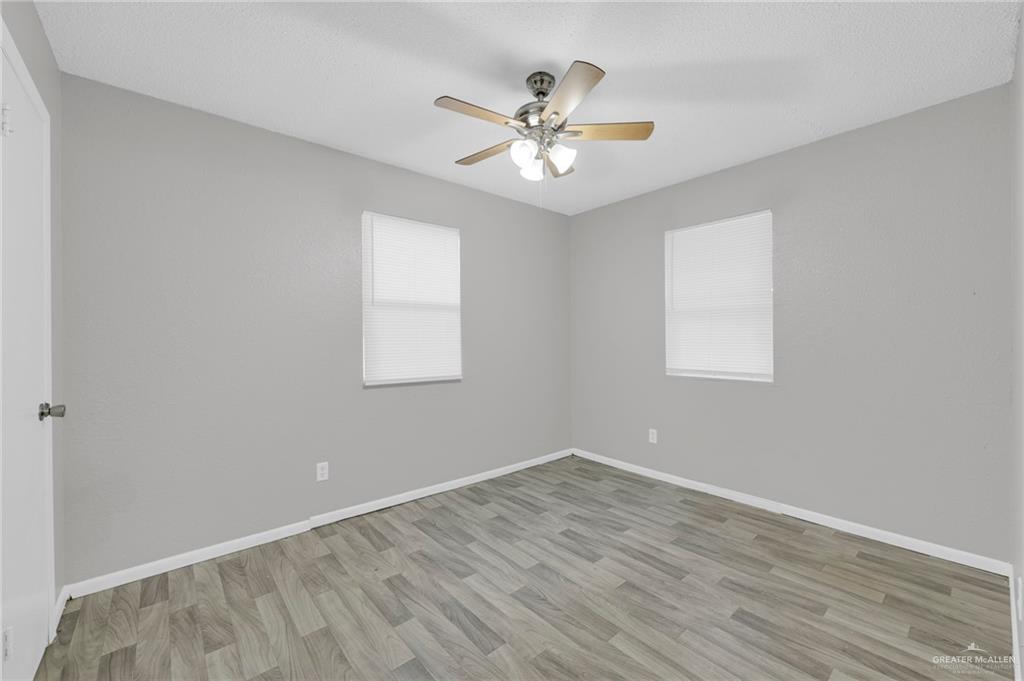 4913 South 26th Street McAllen, TX 78503 - Photo 11 of 15 a view of an empty room with wooden floor and a ceiling fan