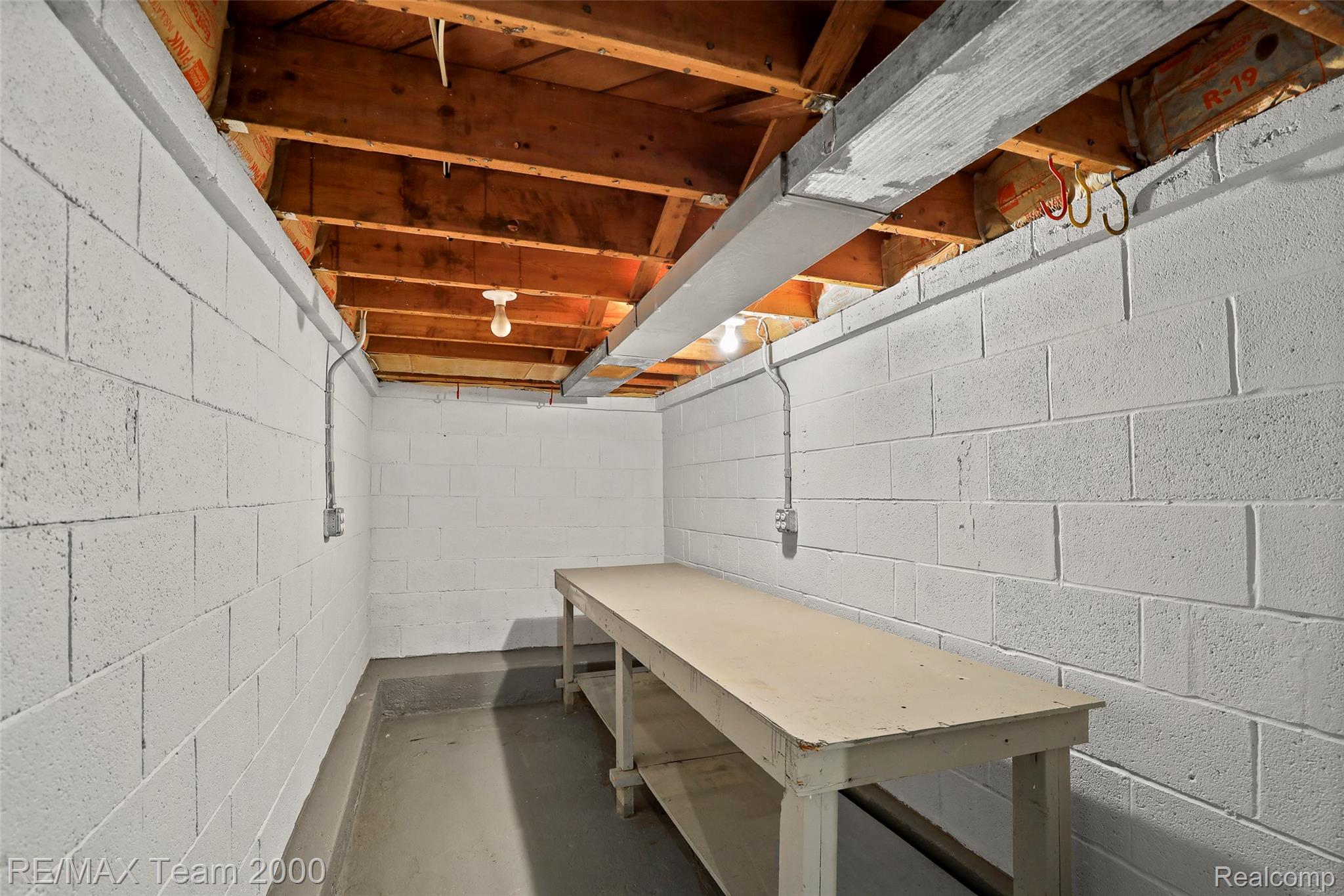 3130 Chestnut Street Dearborn, MI 48124 - Photo 26 of 30 Utility room featuring painted block walls, exposed wood ceiling joists, concrete flooring, and an integrated workbench
