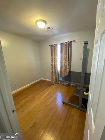 a view of a hallway with wooden floor and staircase