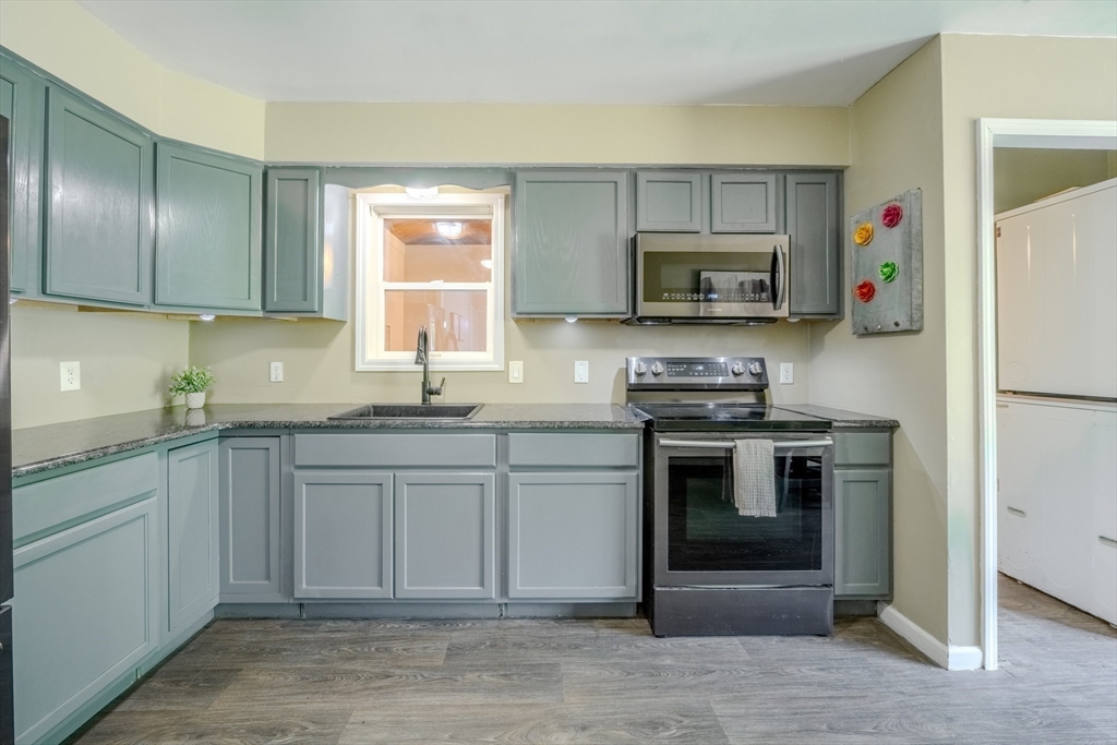 66 Great Road Shirley, MA 01464 - Photo 10 of 40 a kitchen with granite countertop a stove a sink and a microwave