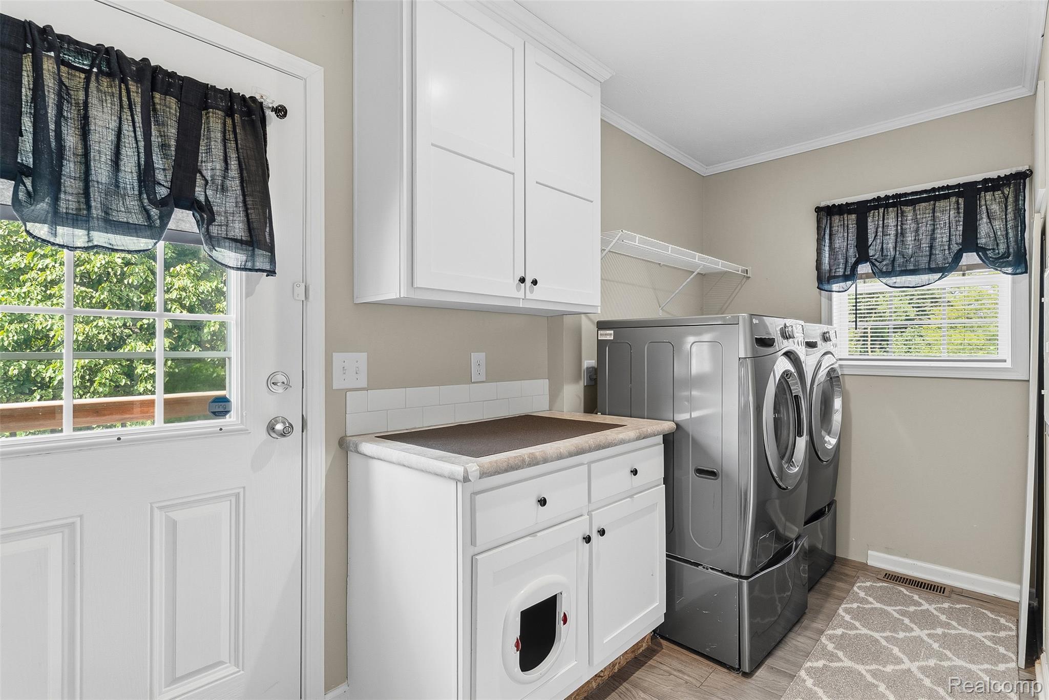 6450 Prince Boulevard Fenton, MI 48430 - Photo 26 of 31 Dedicated laundry area featuring white shaker-style cabinetry, a built-in countertop, and a white subway tile backsplash
