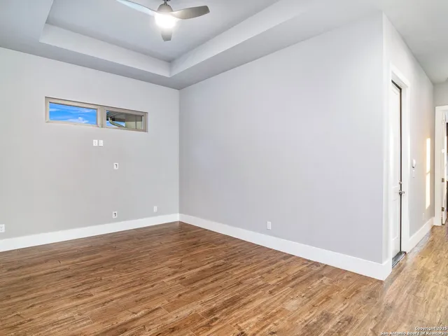 a view of a patio with couches and a table and chairs with wooden floor and fence