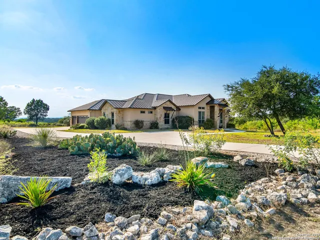 a view of a house with a yard and palm trees