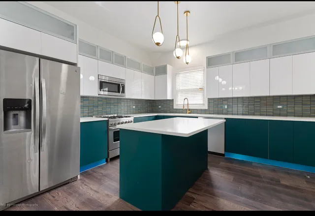 a kitchen with kitchen island granite countertop appliances cabinets and a sink