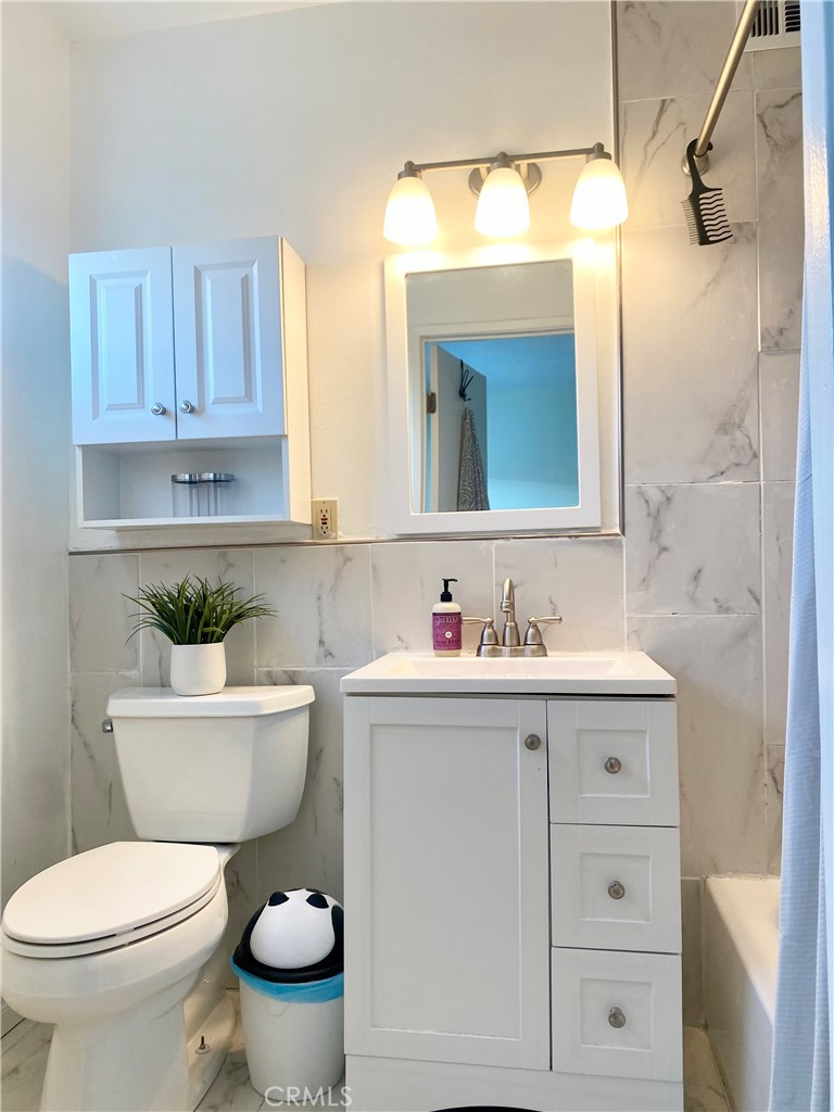 1450 West 146th Street, Unit 2 Gardena, CA 90247 - Photo 28 of 33 a bathroom with a toilet a sink and a mirror