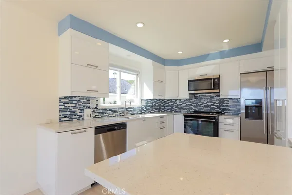a kitchen with stainless steel appliances a stove a microwave a sink and cabinets