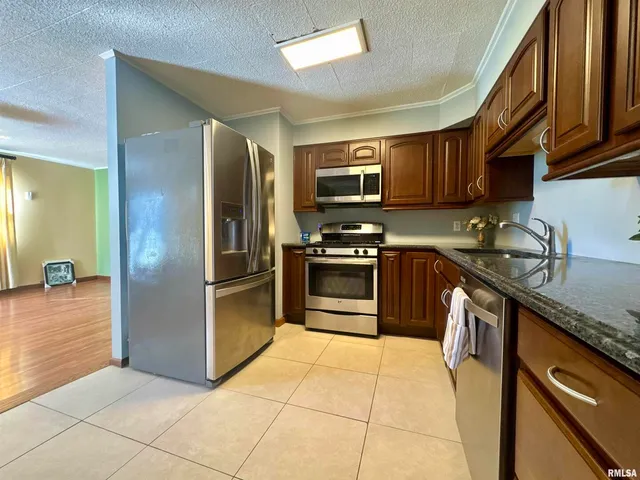 a kitchen with stainless steel appliances granite countertop a stove a sink and a refrigerator