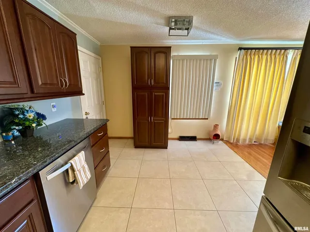 a kitchen with granite countertop a stove a sink and dishwasher wooden cabinets with granite countertops