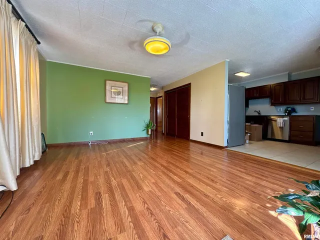 a view of empty room with wooden floor and window