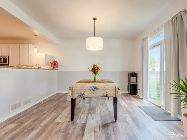 a view of a room with wooden floor table and chairs