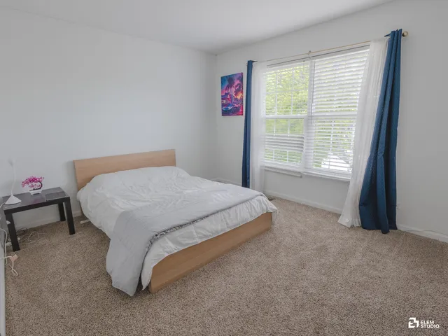 a bed sitting in a bedroom next to a window