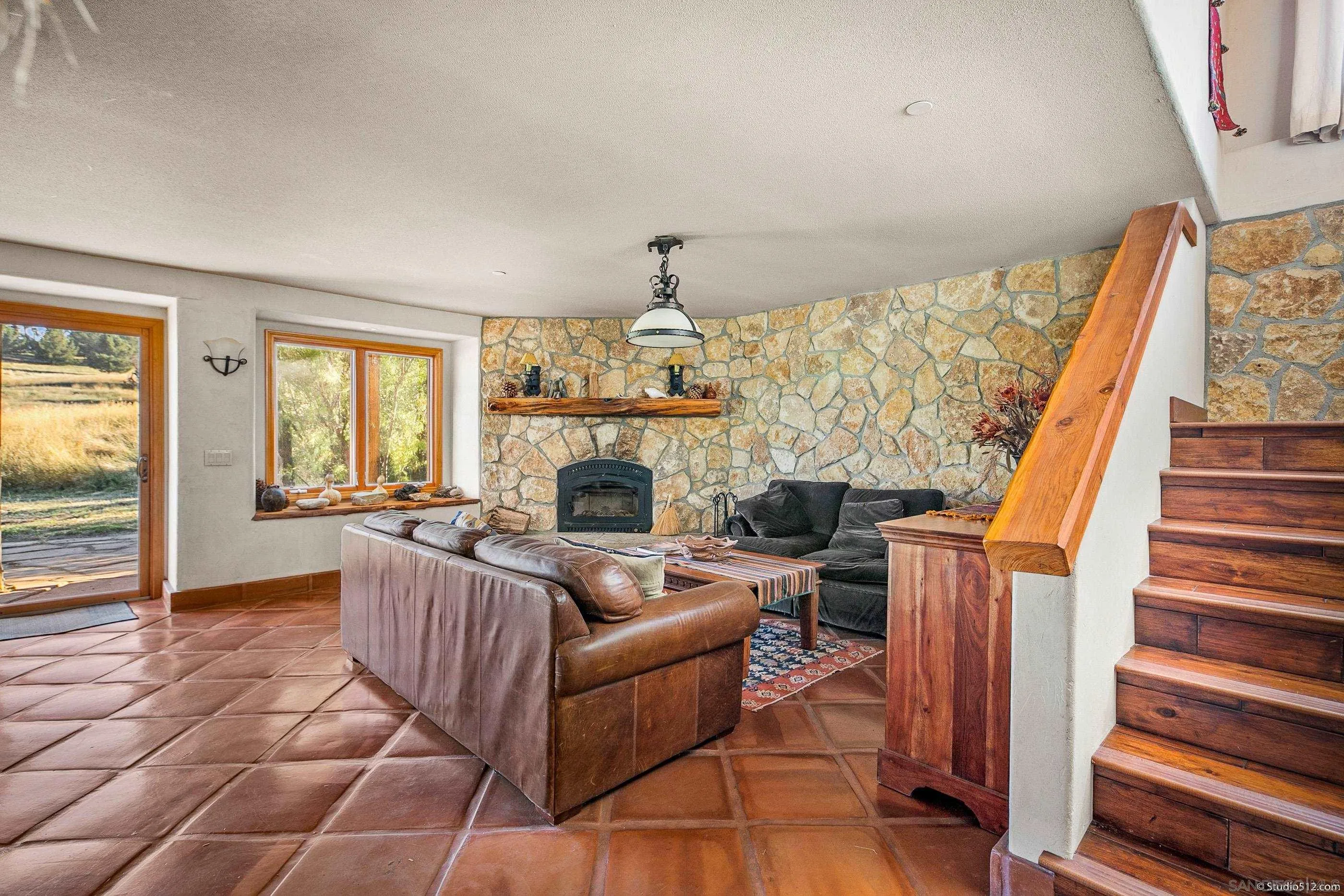 1861 Wynola Road Julian, CA 92036 - Photo 24 of 75 a living room with furniture a fireplace and a floor to ceiling window