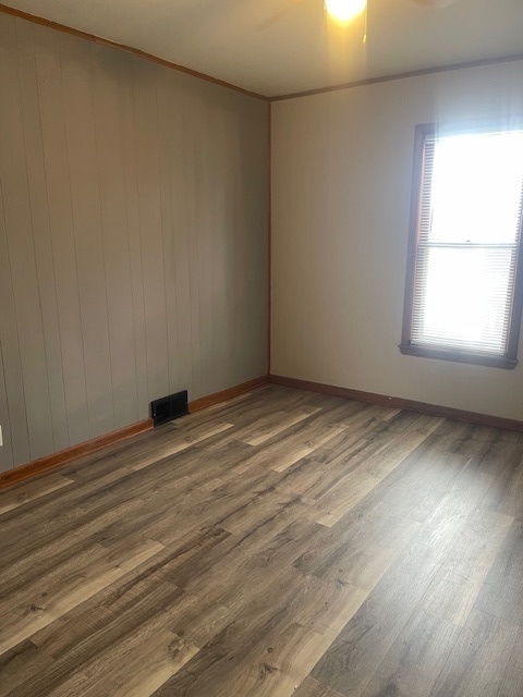 518 College Avenue, Unit 2 DeKalb, IL 60115 - Photo 11 of 13 an empty room with wooden floor and windows