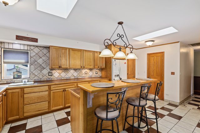 1S225 Valley Road Lombard, IL 60148 - Photo 7 of 46 a kitchen with stainless steel appliances a dining table chairs and white cabinets