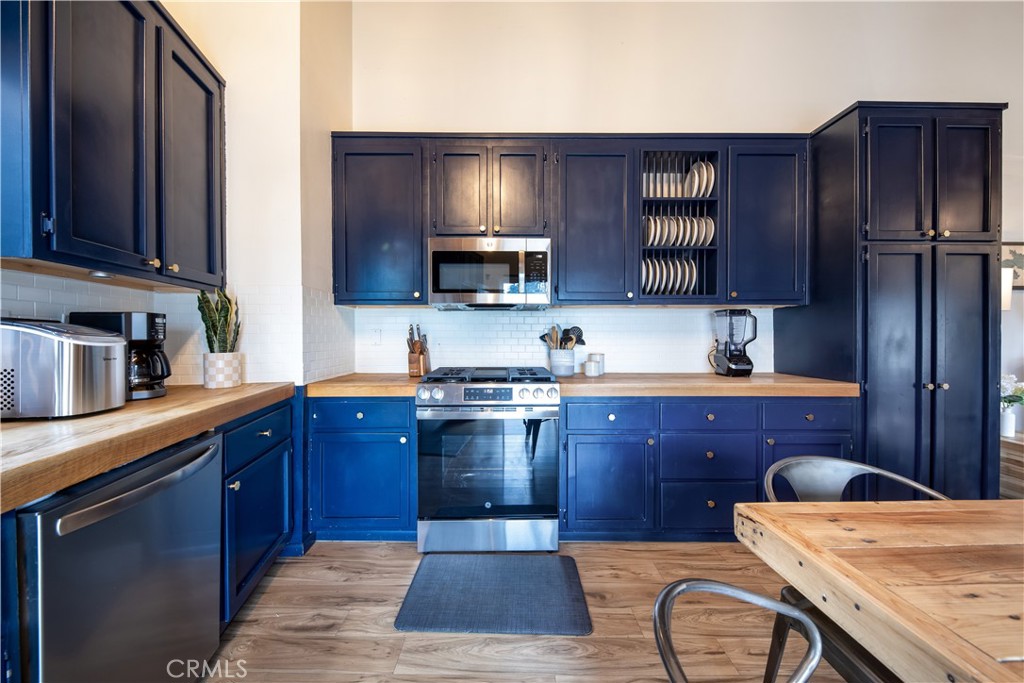 39651 Flicker Road Fawnskin, CA 92333 - Photo 13 of 58 a kitchen with stainless steel appliances granite countertop wooden cabinets a stove top oven a sink and dishwasher