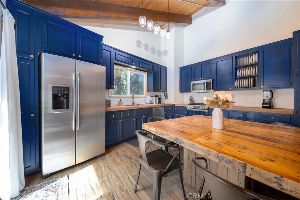 39651 Flicker Road Fawnskin, CA 92333 - Photo 14 of 58 a kitchen with stainless steel appliances granite countertop a sink refrigerator stove microwave and refrigerator