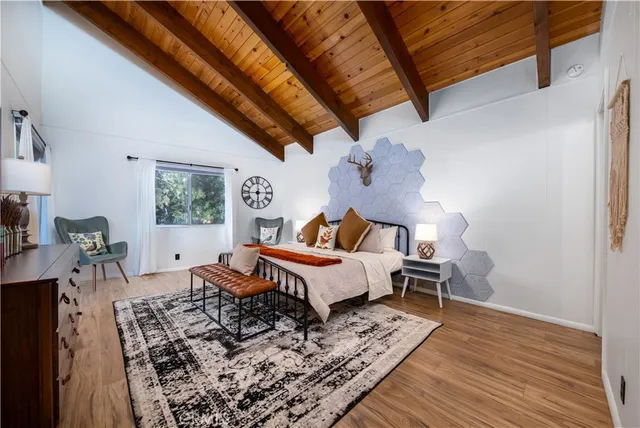 a bedroom with a bed and a flat tv screen on wall