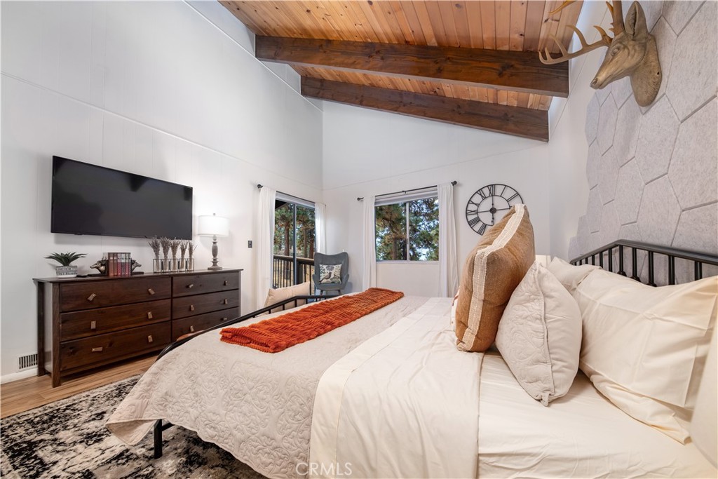 39651 Flicker Road Fawnskin, CA 92333 - Photo 18 of 58 a bedroom with a bed and a flat tv screen on wall