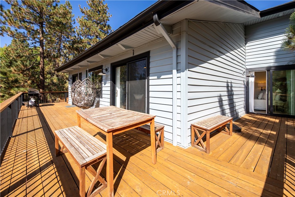 39651 Flicker Road Fawnskin, CA 92333 - Photo 27 of 58 a view of a patio with table and chairs with wooden floor and fence