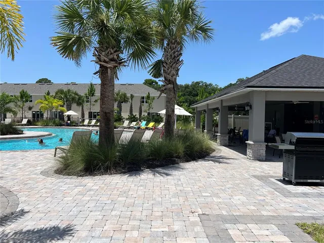 a view of a house with a yard and palm tree