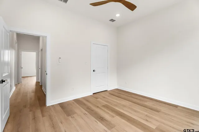 a view of a big room with wooden floor closet and chandelier fan