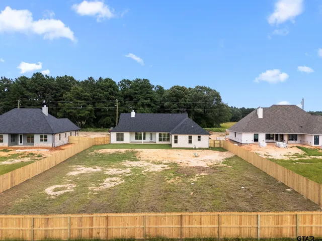 a white house covered with tall trees