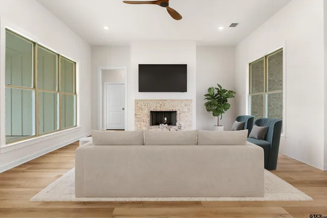 a living room with furniture a flat screen tv and a fireplace