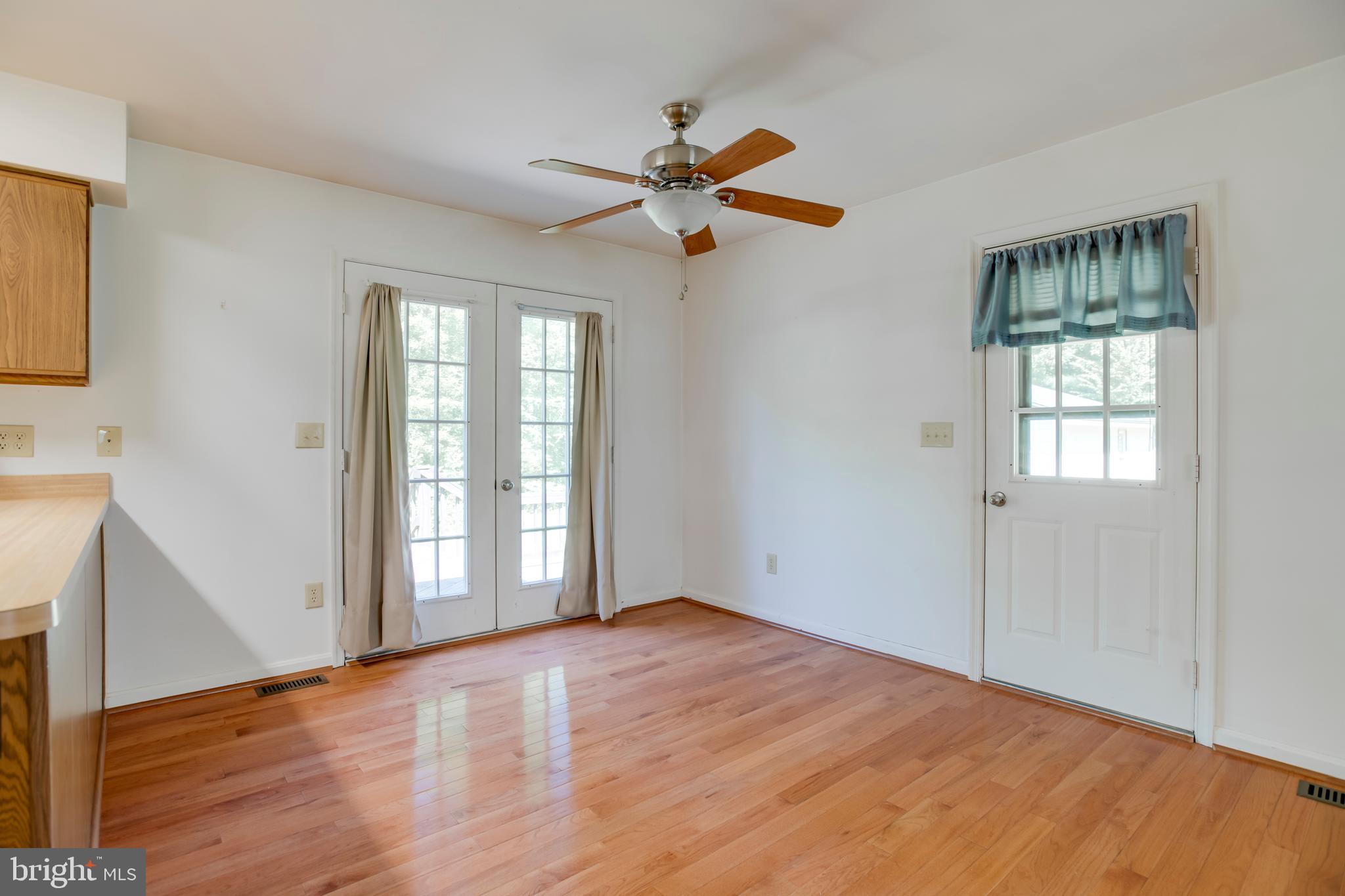 803 Weaver Hollow Road Banco, VA 22711 - Photo 8 of 67 a view of empty room with wooden floor and fan