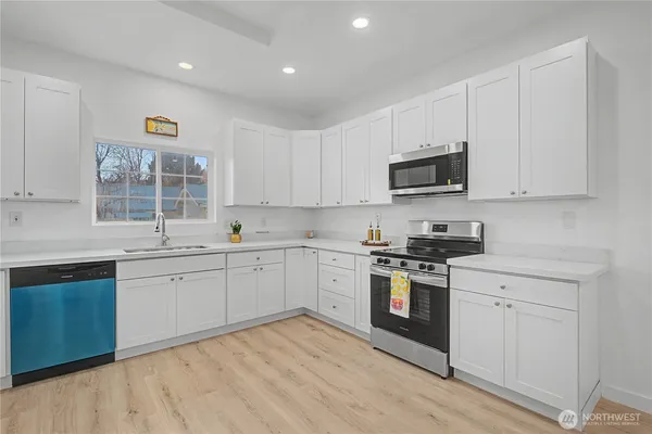 a kitchen with cabinets stainless steel appliances and a window