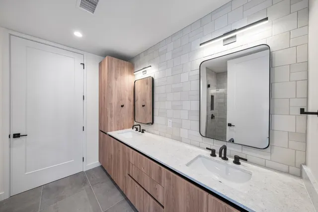 a bathroom with double vanity sinks and a mirror
