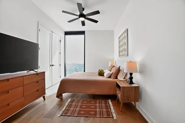 a bedroom with a bed and a flat tv screen on dresser