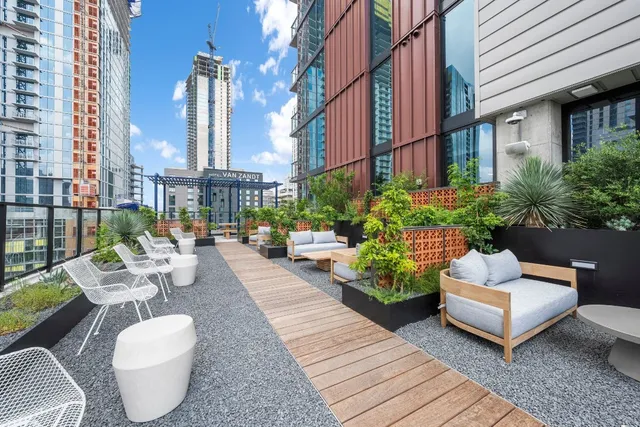 a view of a patio with couches table and chairs and potted plants