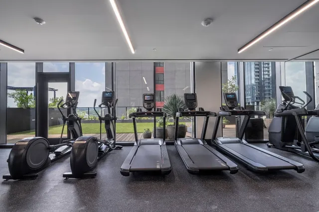 a room with gym equipment and large windows