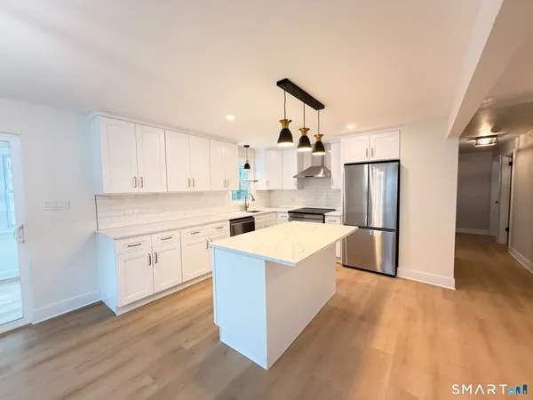 a kitchen with white cabinets and white appliances