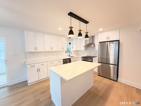 a kitchen with white cabinets and stainless steel appliances