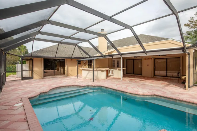a porch with a table and chairs under an umbrella