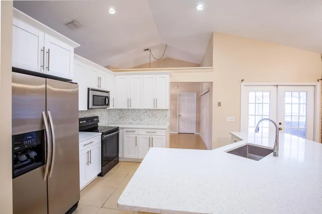 a kitchen with stainless steel appliances a refrigerator sink and stove