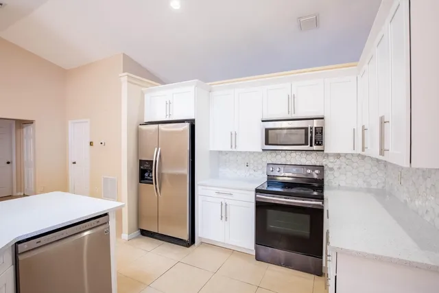 a kitchen with stainless steel appliances granite countertop a refrigerator stove and microwave