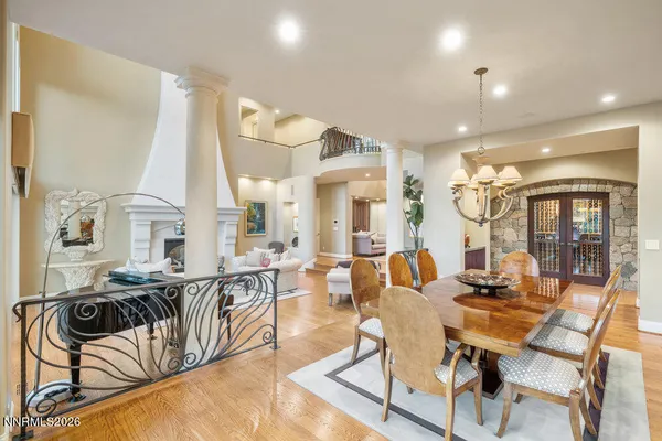 a dining room with furniture a chandelier and wooden floor