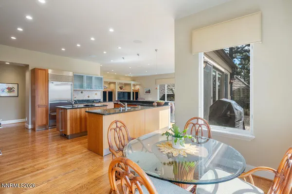 a kitchen with stainless steel appliances granite countertop a refrigerator a sink a stove and a wooden floors
