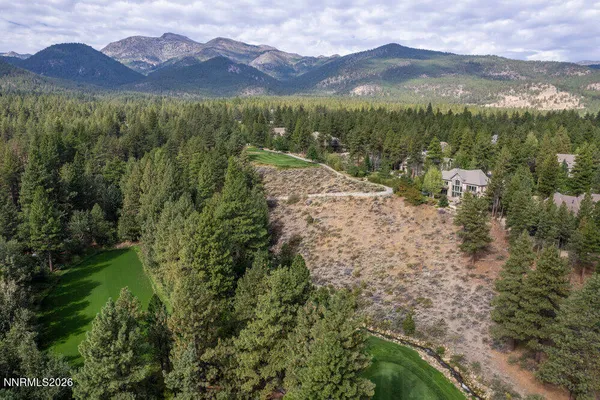 a front view of a house with a yard and green space