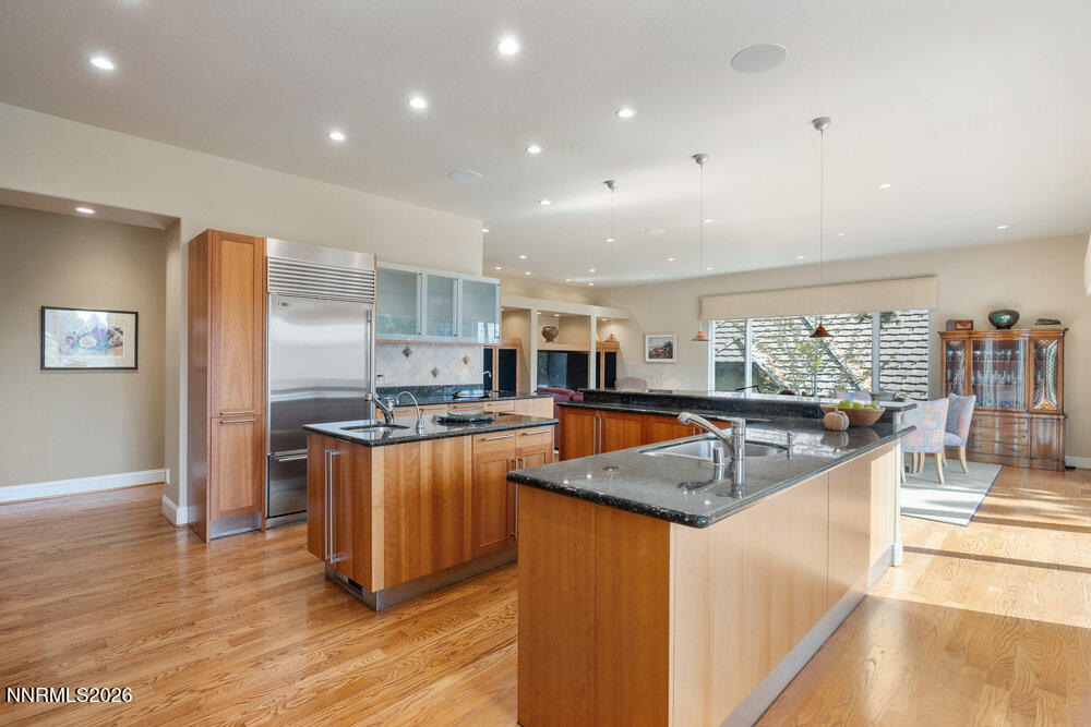 6065 Lake Geneva Drive Reno, NV 89511 - Photo 51 of 101 a kitchen with stainless steel appliances granite countertop a refrigerator a sink a stove and a wooden floors
