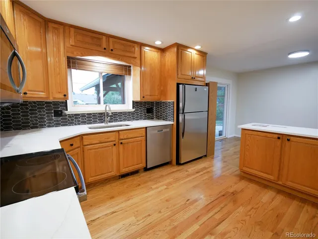 a kitchen with stainless steel appliances granite countertop a sink and a refrigerator
