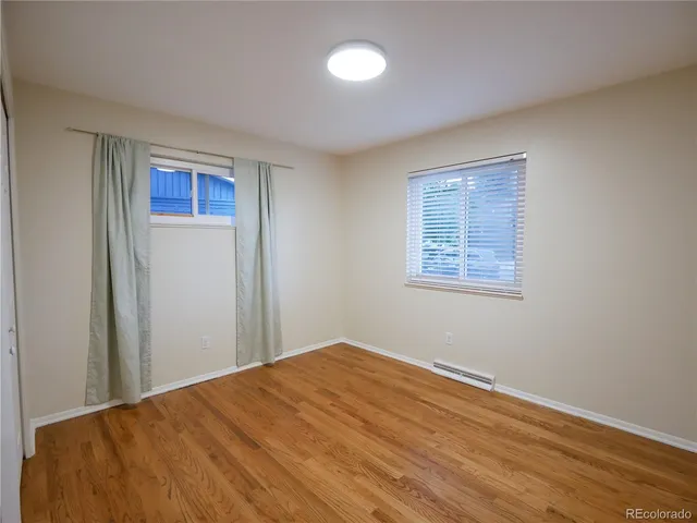 a view of a big room with wooden floor and windows
