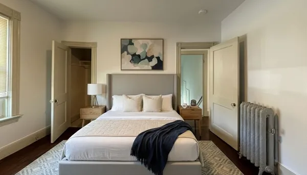 a bedroom with a bed and a painting on the wall