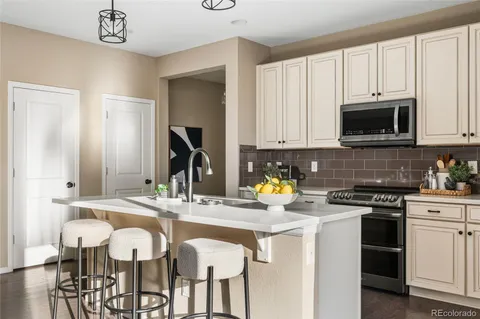 a kitchen with a sink stove and white cabinets