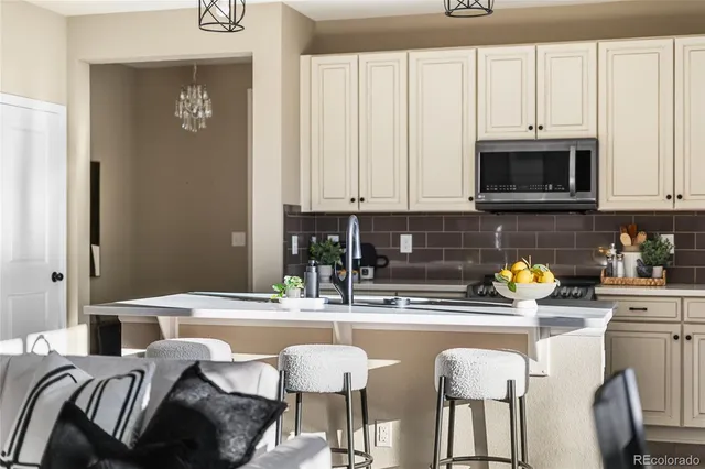 a kitchen with stainless steel appliances kitchen island granite countertop a sink and a white cabinets
