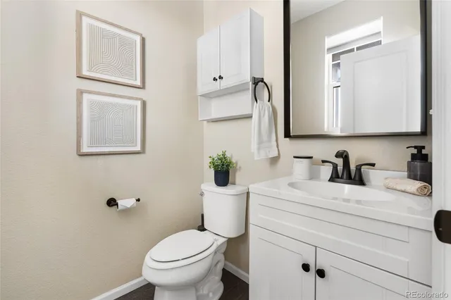 a bathroom with a granite countertop toilet sink and mirror